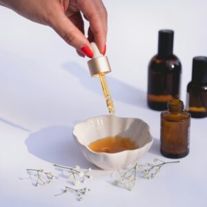 Stylish composition of a skincare routine with dropper bottles and dried flowers on a white background.